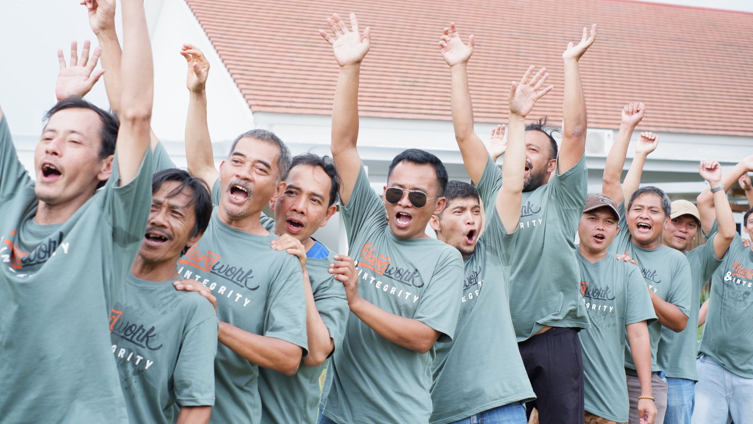 Peserta outing kantor bersorak sambil mengangkat tangan saat yel-yel kelompok