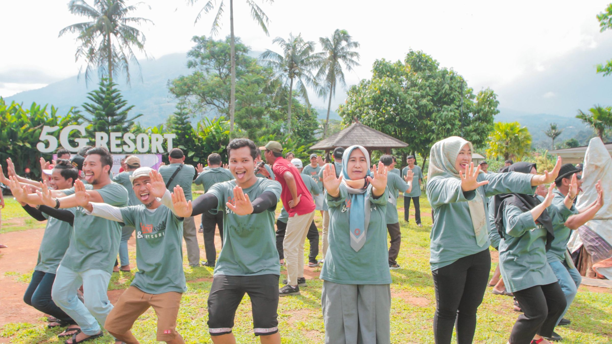 Peserta gathering senam bersama di lapangan rumput dengan latar pegunungan