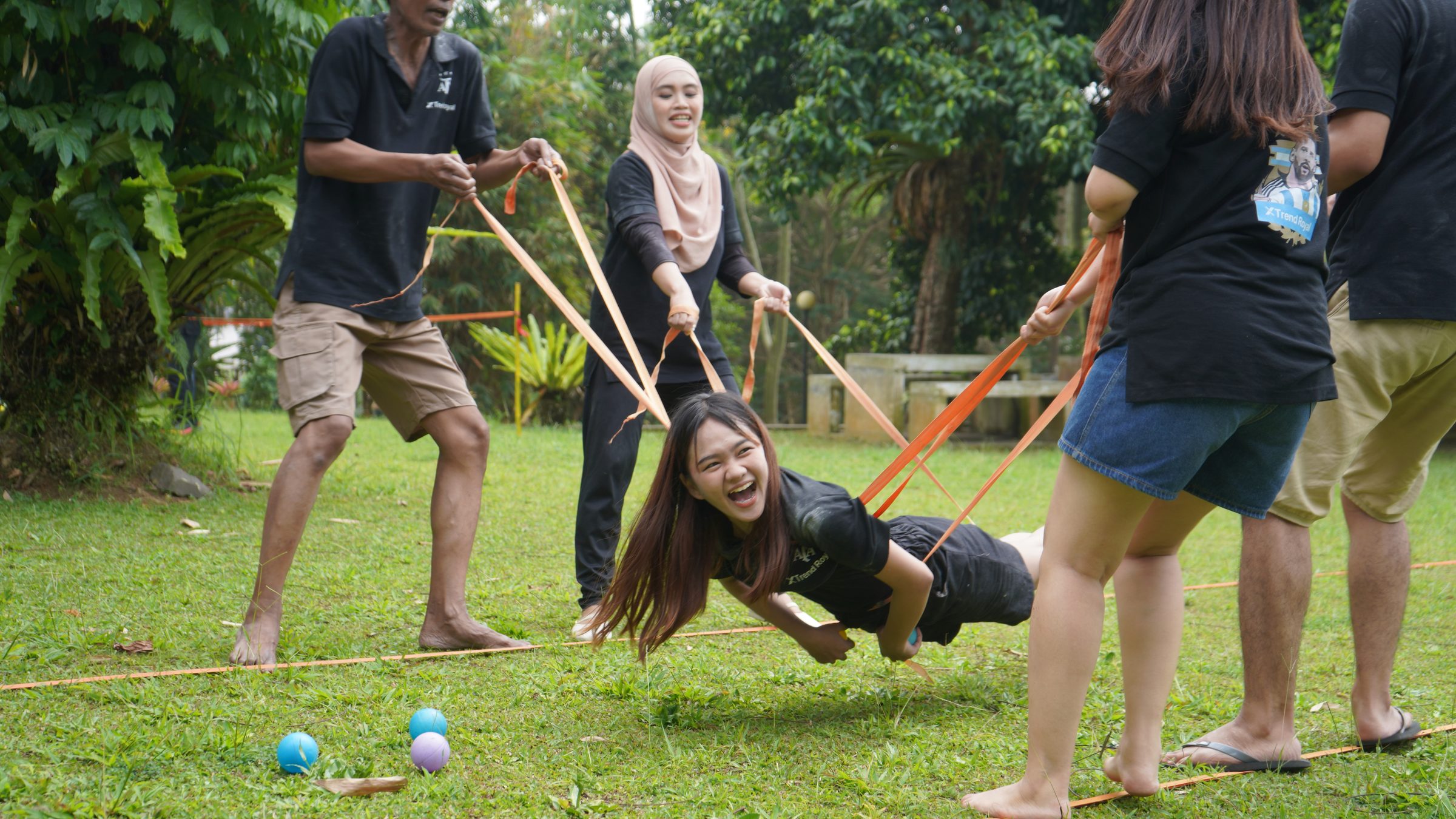 Peserta melayang ditarik ketapel raksasa dari pita elastis dalam permainan kelompok